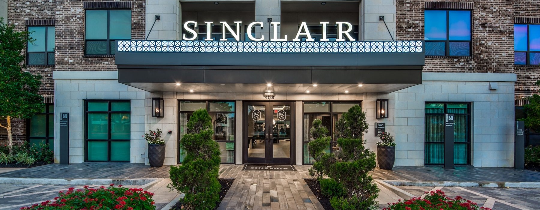 a building with a walkway and plants in front of it